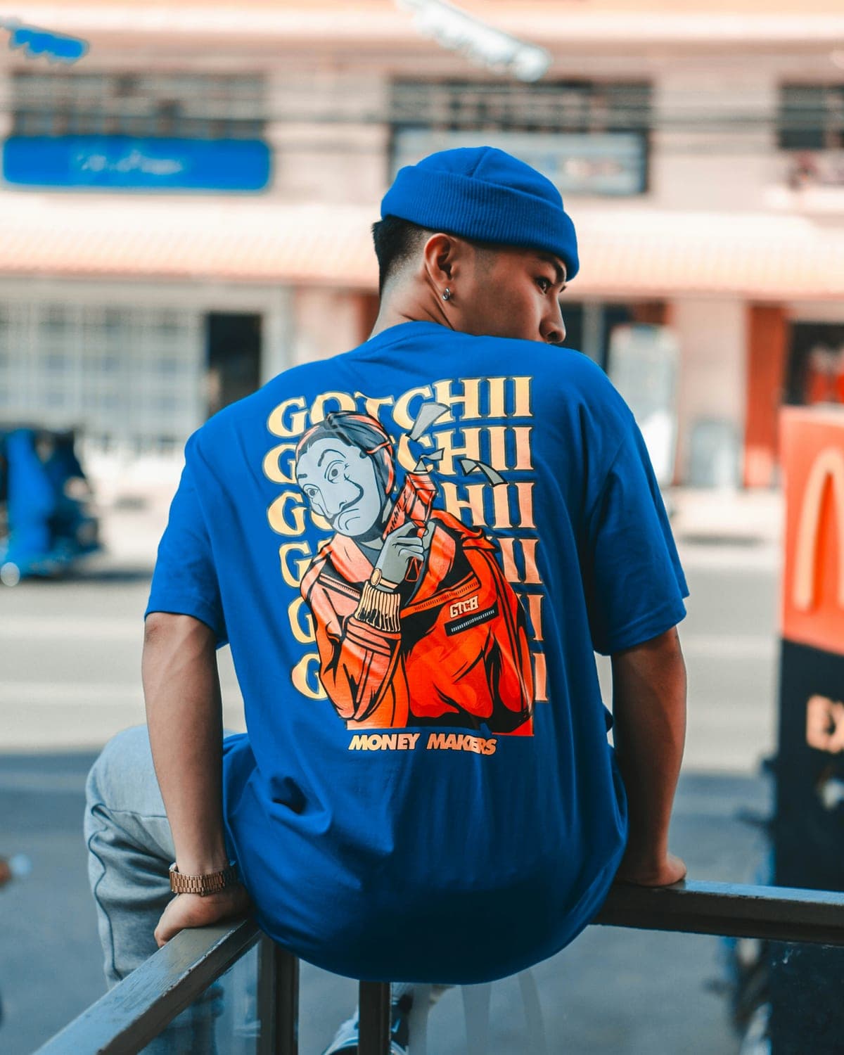 Man wearing a royal blue t-shirt with a large custom graphic printed across the back